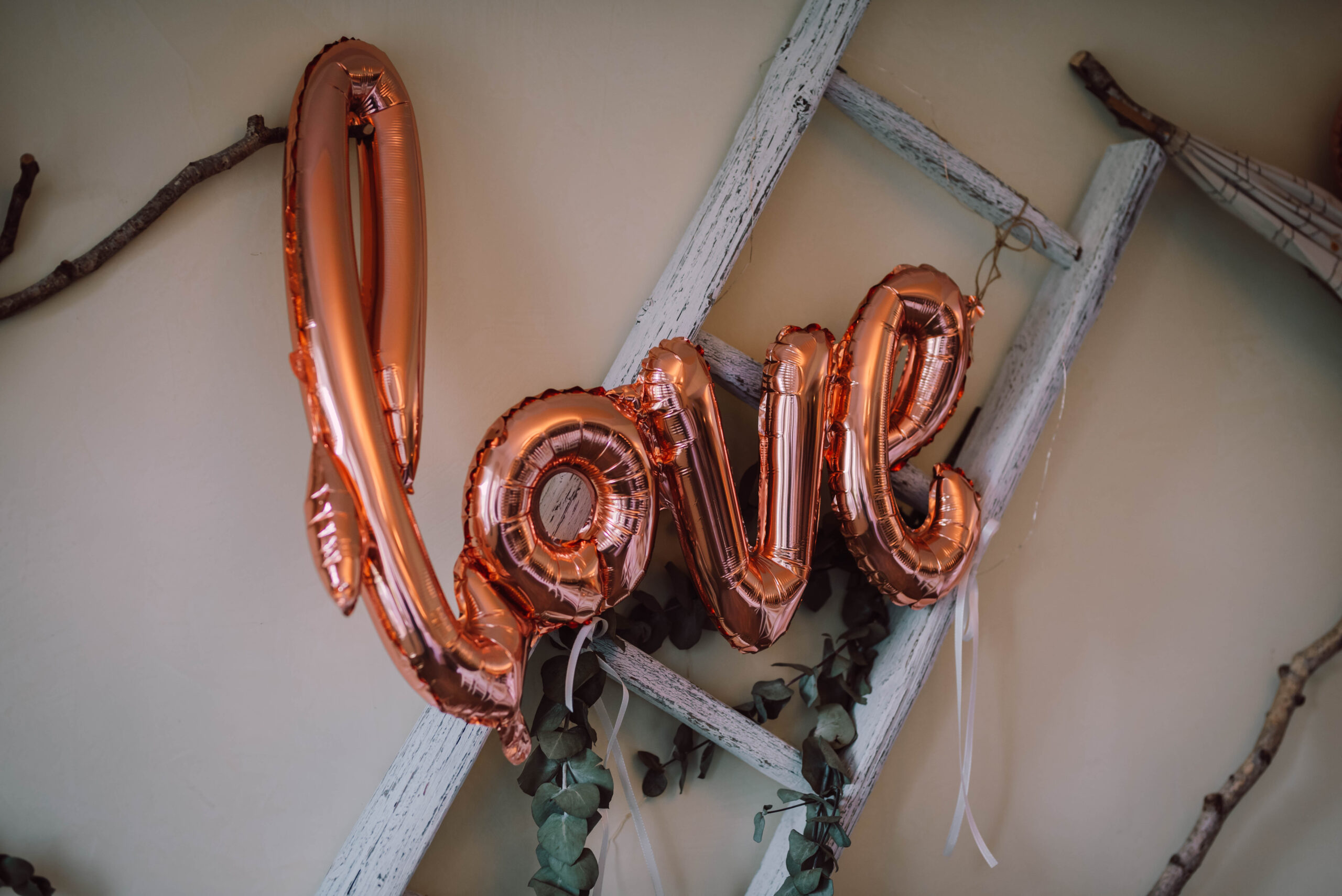 luftballons in dem schriftzug love hängt als hochzeitsdekoration an der wand