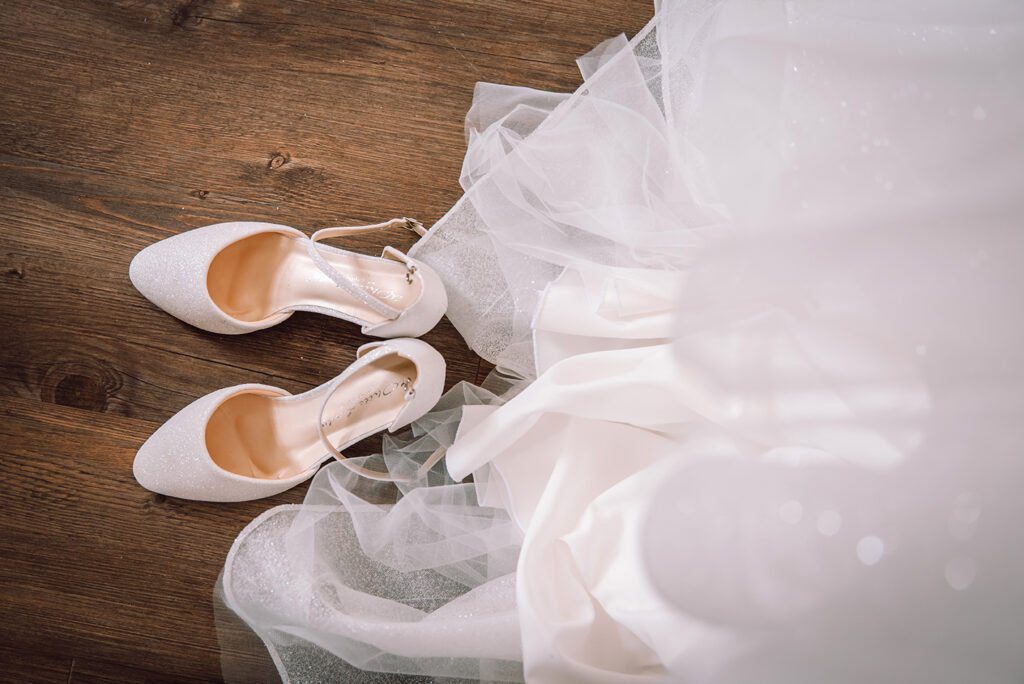 getting ready detailaufnahem von brautschuhen und brautkleid aus der vogelperspektive als hochzeitsdetail